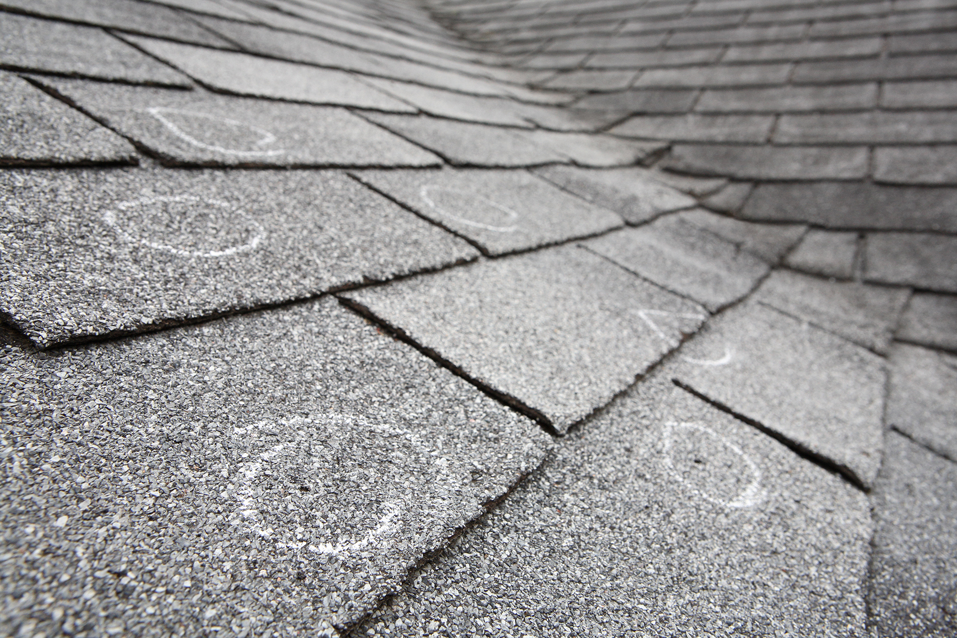 Old roof with hail damaged shingles, chalk circles mark the damage shingles, chalk circles mark the damage